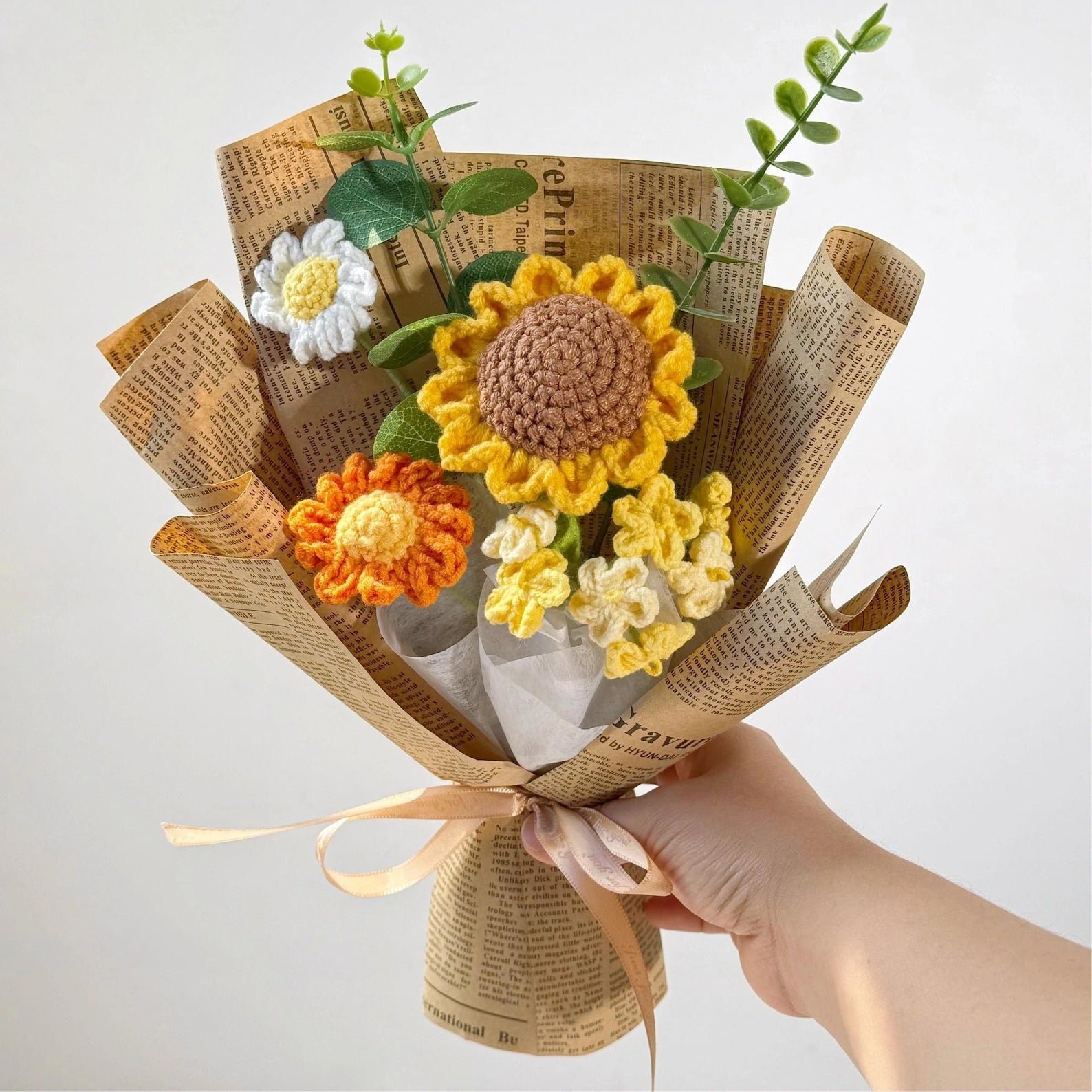 Gehäkelter Sonnenblumenstrauß mit Vintage-Papier